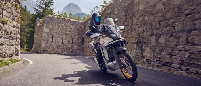 moto-honda-transalp-em-curva-cercada-por-paredes-de-pedra